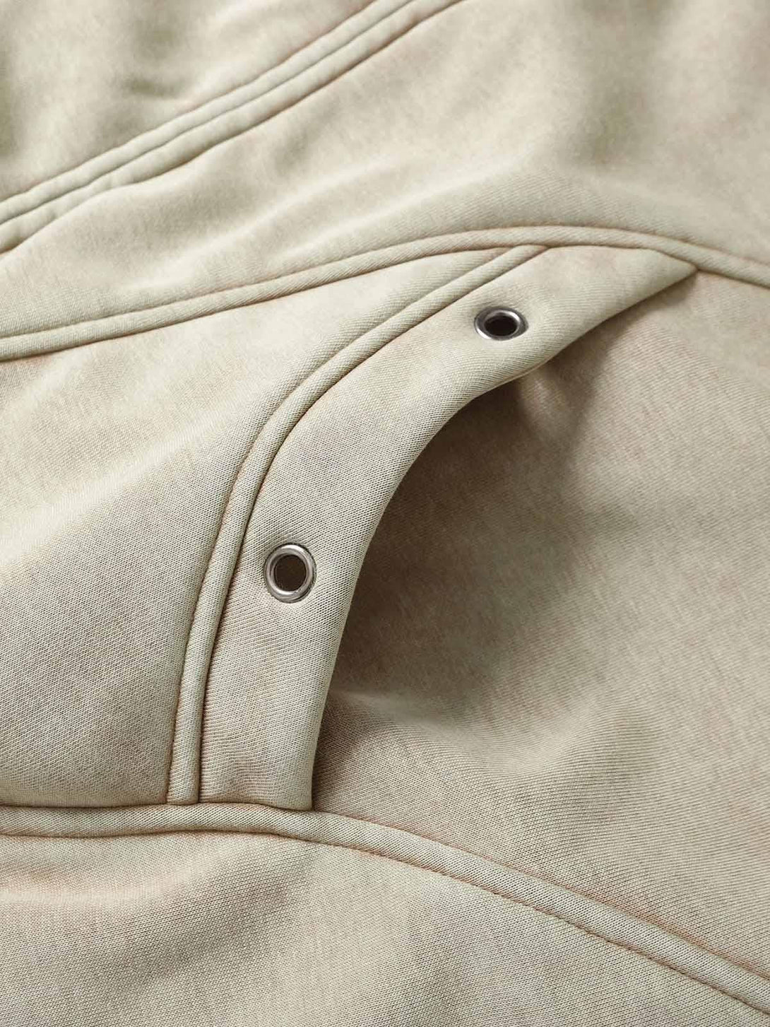 Intricate look at TALISHKO's washed zipper-up sweatshirt, showcasing stylish grommet details.