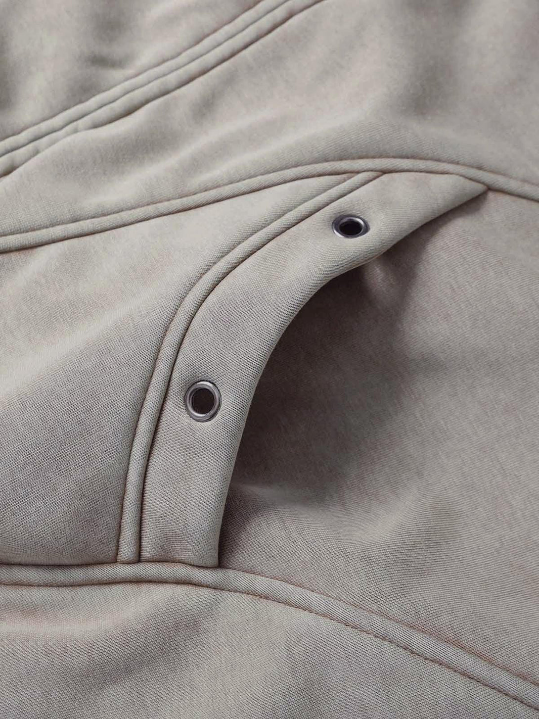 A tight crop highlighting TALISHKO's washed zipper-up sweatshirt with grommet and stitching details.