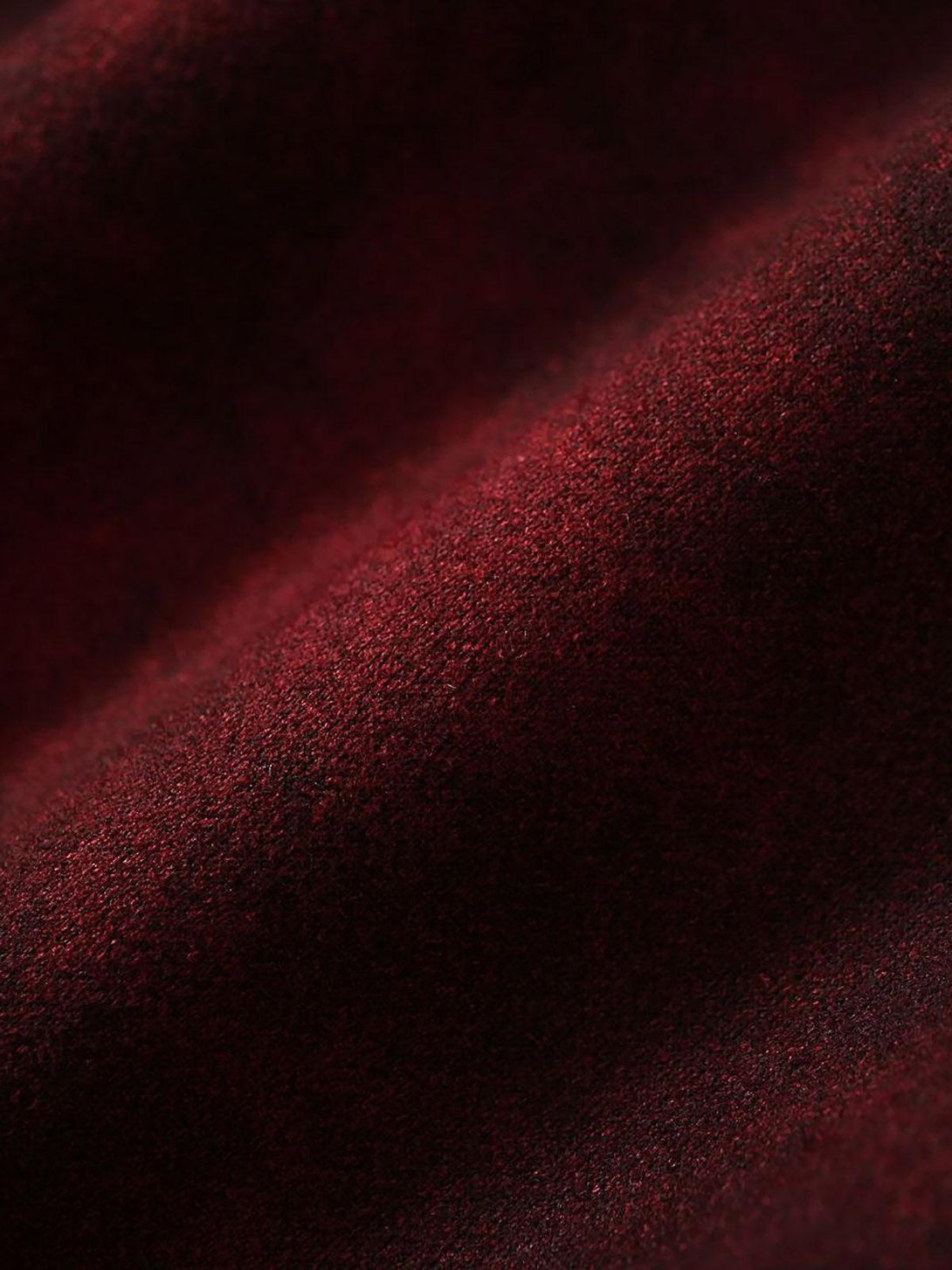 "Rich red fabric texture of TALISHKO's jacket, highlighting its intricate and cozy design."