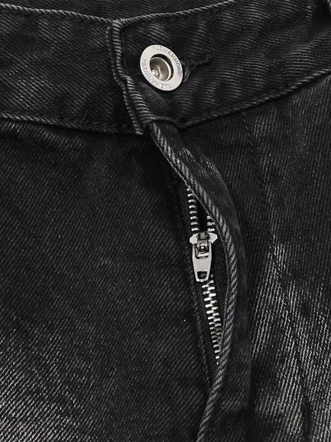 A close-up of TALISHKO cargo jeans zipper and button, showcasing the textured black fabric.