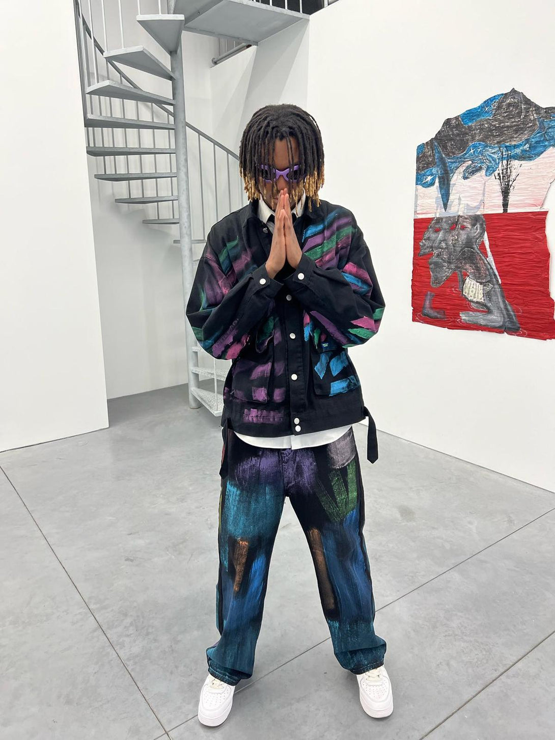 Model wearing TALISHKO watercolor print jeans and jacket, featuring vibrant, artistic patterns.