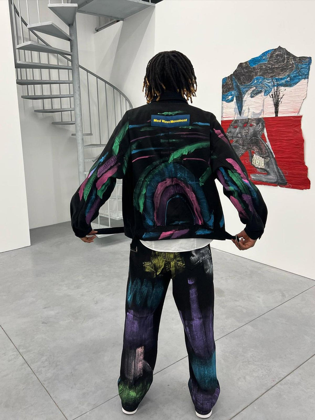 A model wearing TALISHKO watercolor print jeans and jacket, showcasing vibrant artistic design.