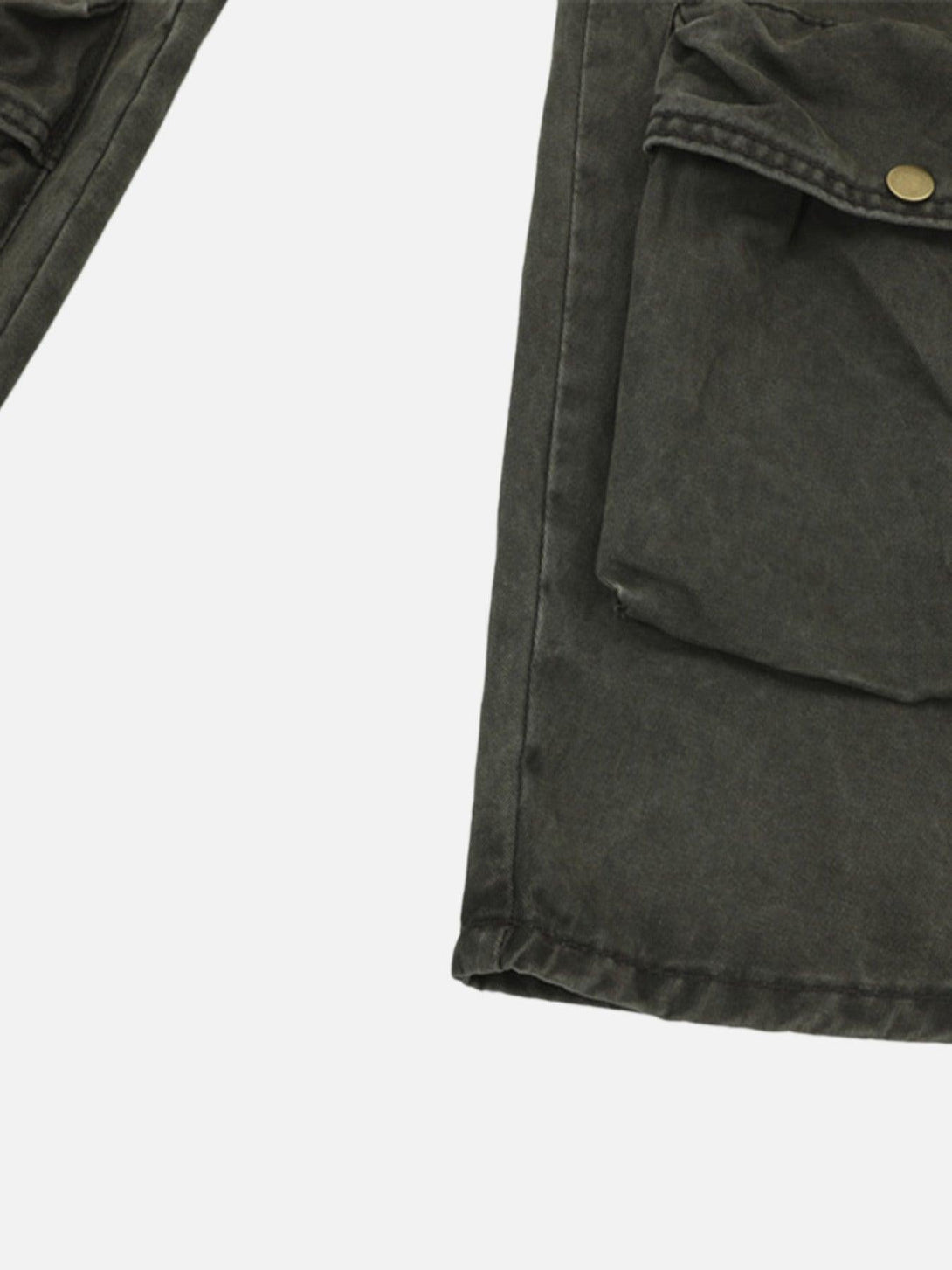A detailed view of TALISHKO's baggy denim overalls, focusing on the utility pocket design.
