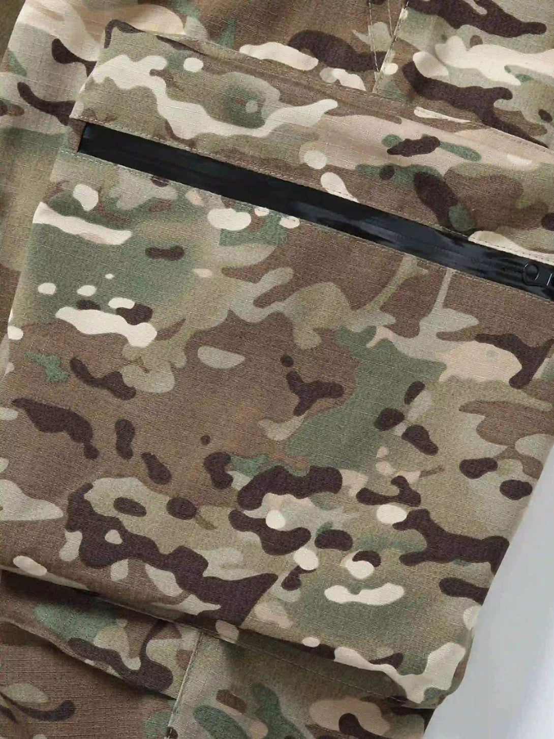 A tight crop highlighting the pocket design of TALISHKO camouflage pants, showcasing street style.