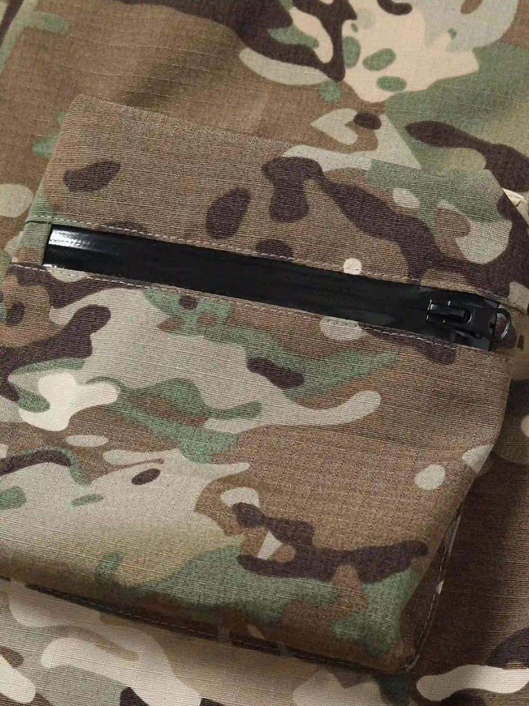A detailed view of the zipper pocket on TALISHKO camouflage pants, emphasizing streetwear style.