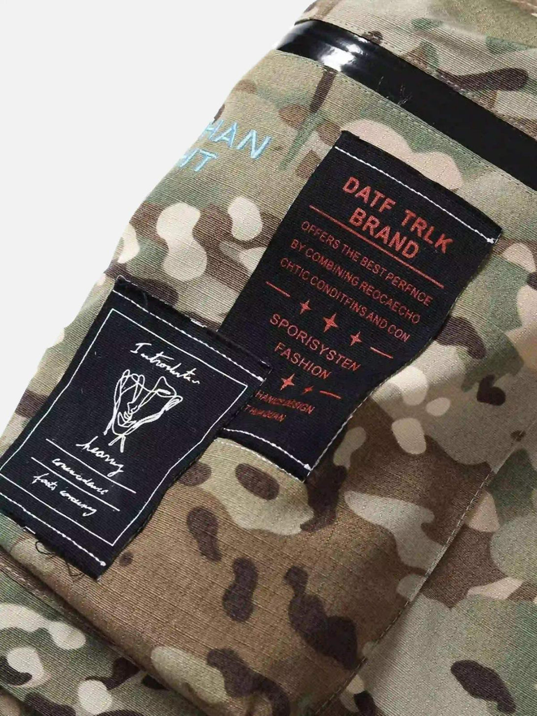 Close-up of TALISHKO camouflage pants with detailed patchwork, highlighting streetwear elements.