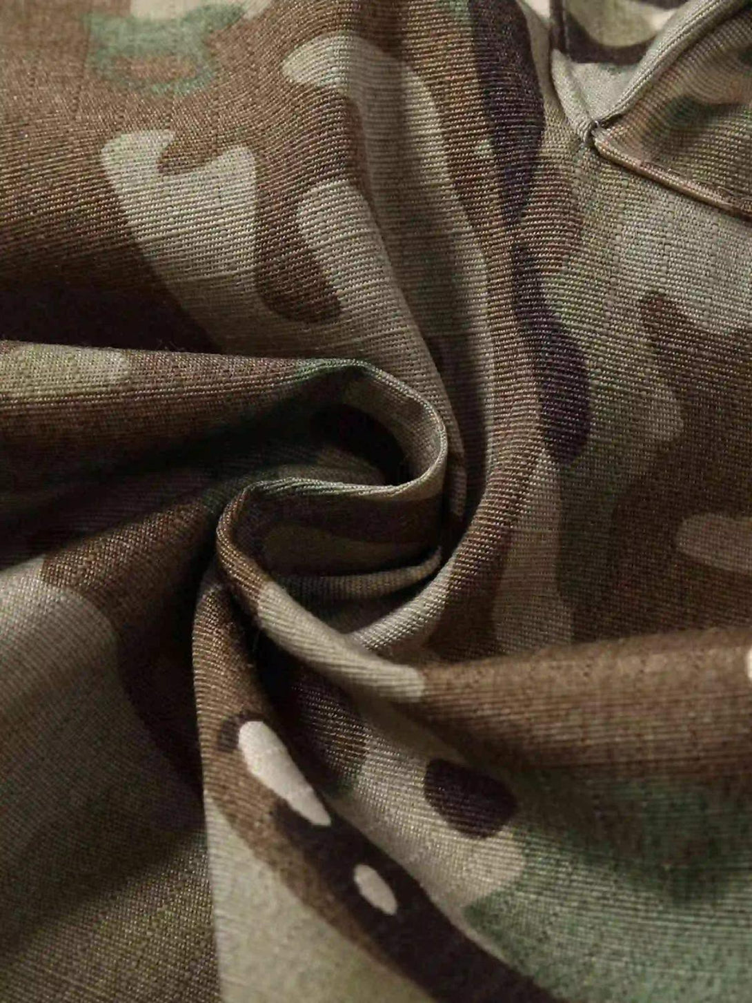Zoomed-in swirl of TALISHKO camouflage fabric, highlighting texture and streetwear style.