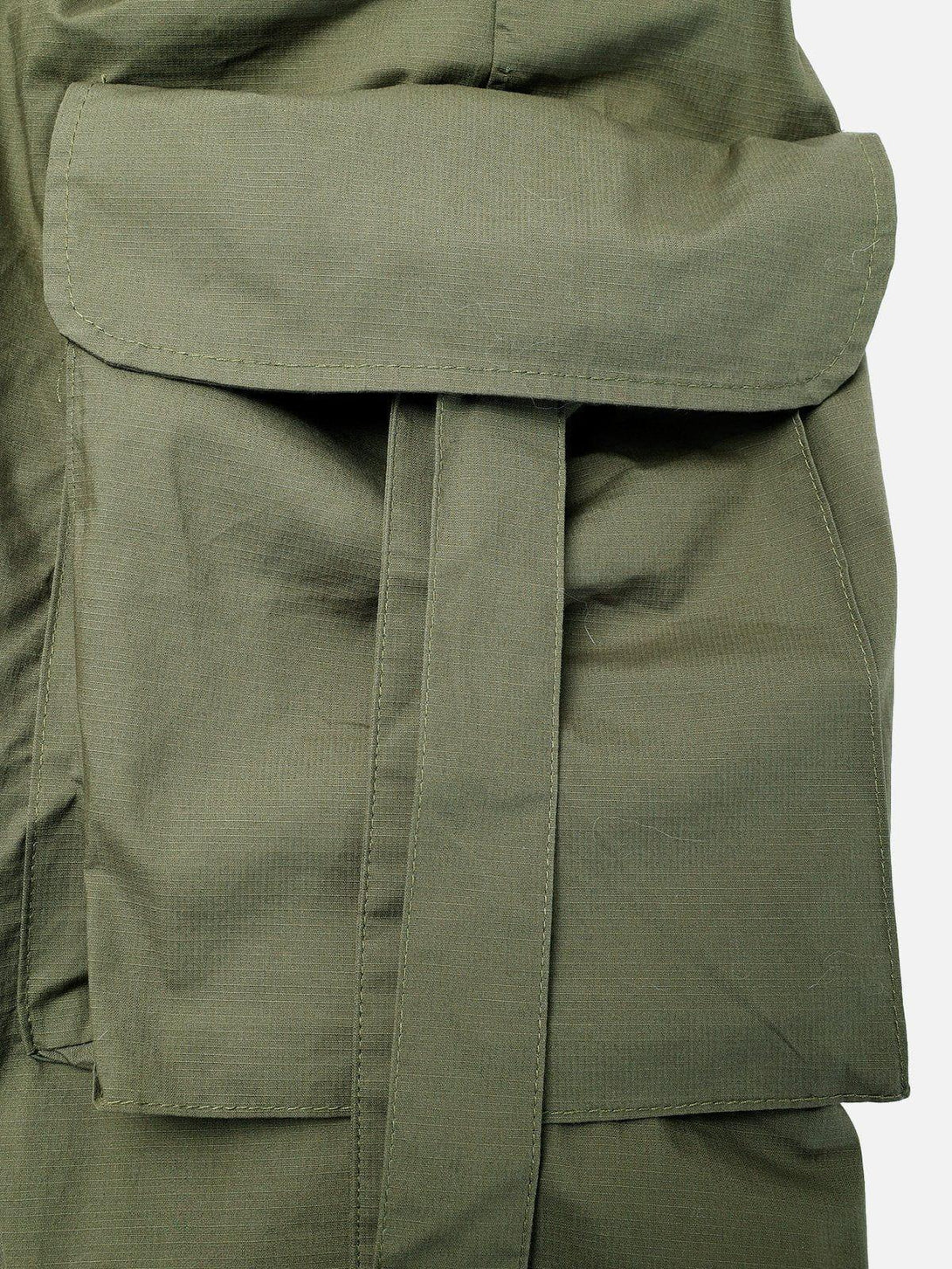 Intricate look at TALISHKO's olive shorts highlighting the woven ribbon and spacious pocket detail.