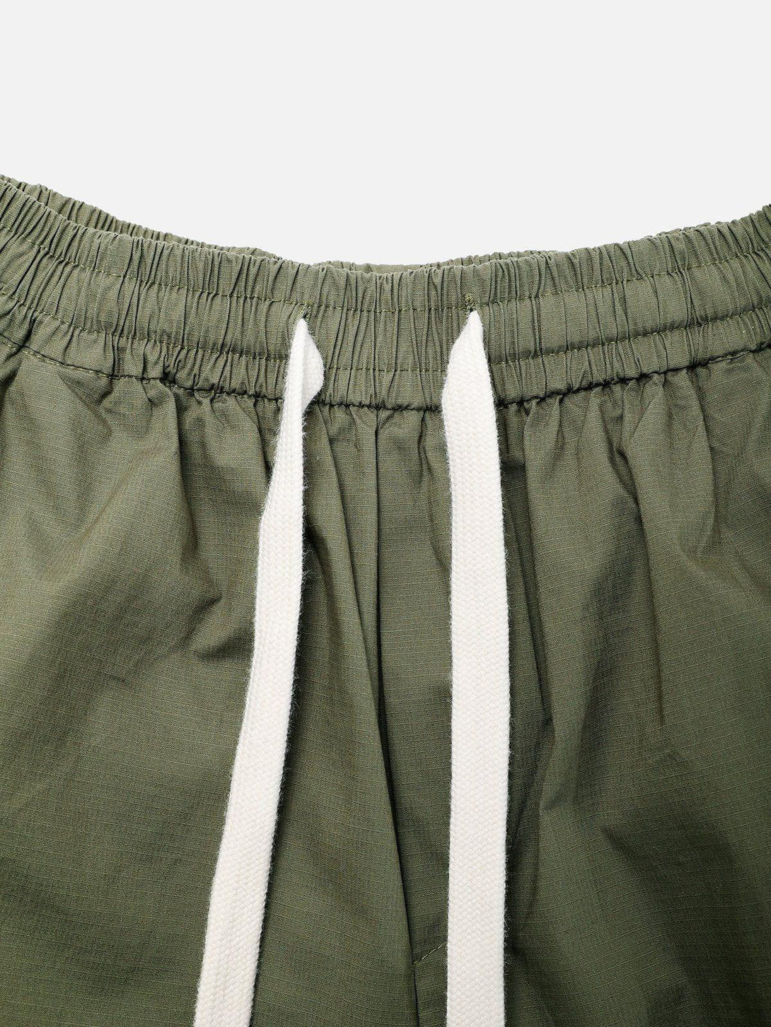Intricate look at TALISHKO's olive shorts with white drawstrings and elastic waistband detail.