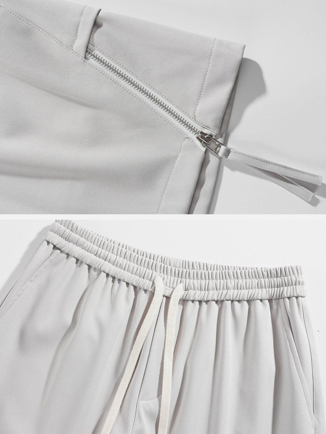 A close-up of gray drawstring shorts by TALISHKO, showcasing zipper detail and elastic waist.